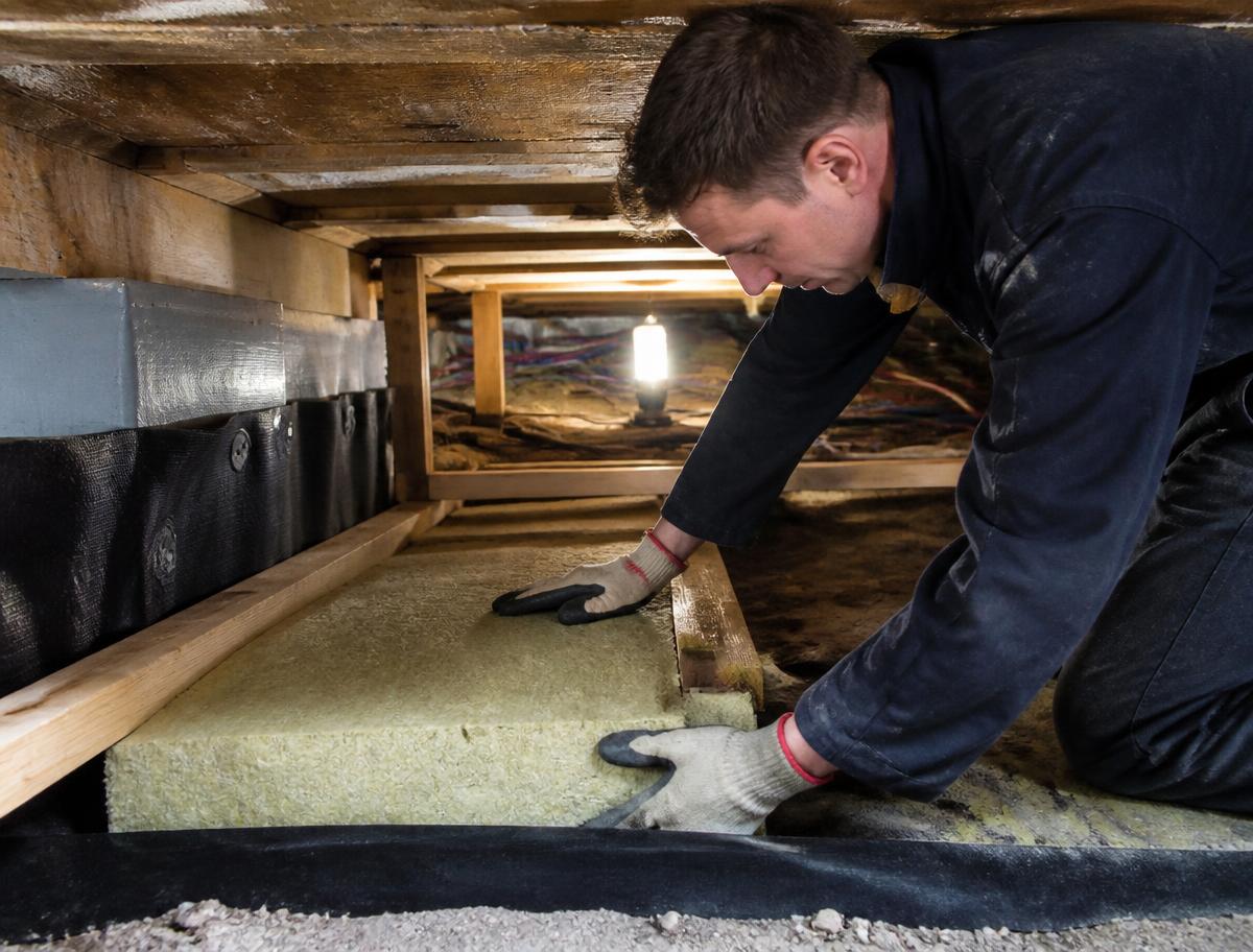 Isolatieplaten worden onder de begane grondvloer tussen de balken geplaatst